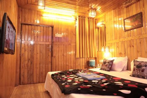 a bedroom with a bed in a room with wooden walls at Altaf's motel in Matheran