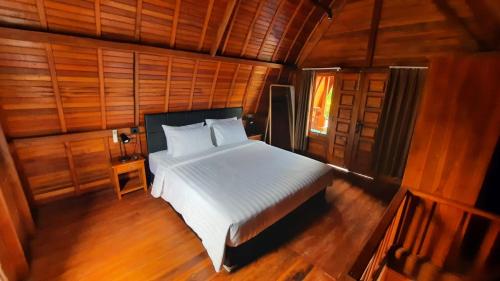 Postel nebo postele na pokoji v ubytování Kayu Joglos Ubud