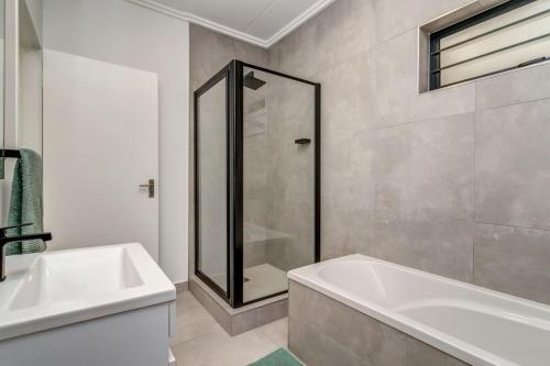 ein Badezimmer mit Dusche, Badewanne und Waschbecken in der Unterkunft Country Charm 2Bed 2Bath Fourways Sandton in Chartwell