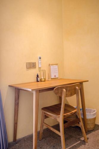 a wooden desk with a chair next to a wall at Mimpi Tropis in Badung