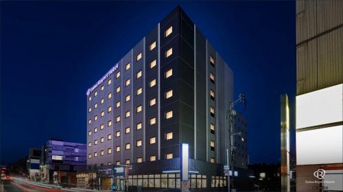 a tall black building with windows on a city street at Daiwa Roynet Hotel Morioka in Morioka