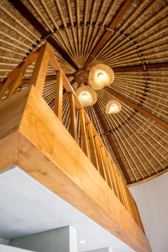 a wooden ceiling with two lights on it at Mimpi Tropis in Badung