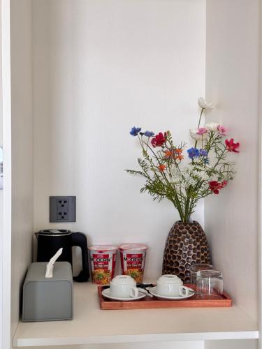 a shelf with a toaster and a vase with flowers at Lá Riverside Boutique Hotel in Mỹ Phước