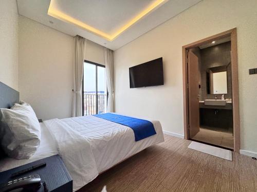 a hotel room with a bed and a television at Lá Riverside Boutique Hotel in Mỹ Phước