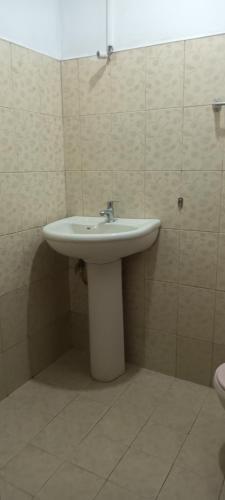 a bathroom with a white sink and a toilet at Choice hotels in Haputale