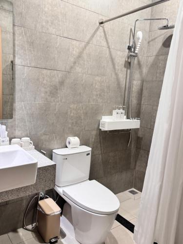 a bathroom with a toilet and a sink and a shower at Lá Riverside Boutique Hotel in Mỹ Phước