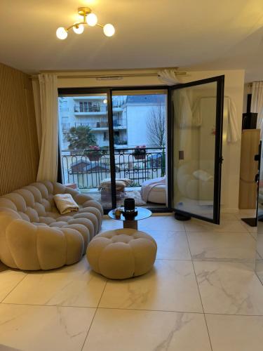 un salon avec deux canapés et une grande fenêtre dans l'établissement Villamelina, à Puteaux