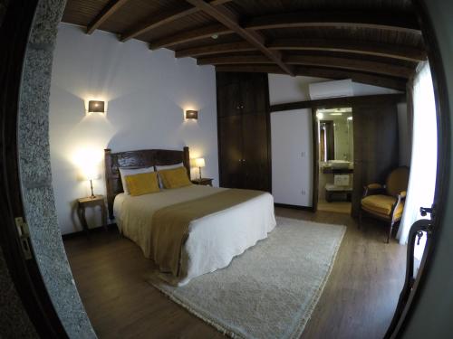 - une chambre avec un grand lit et une chaise dans l'établissement Puial de l Douro, à Miranda do Douro