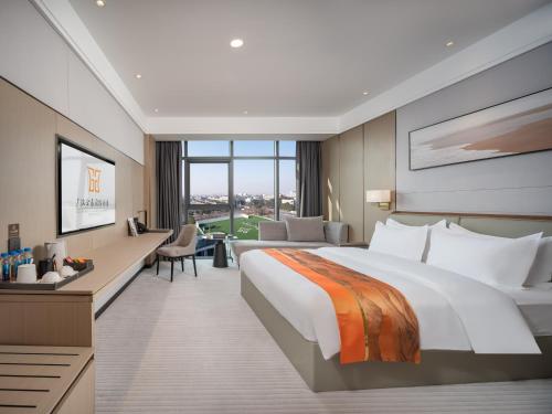 a hotel room with a large bed and a desk at Guanghan Exhibition International Hotel in Guanghan