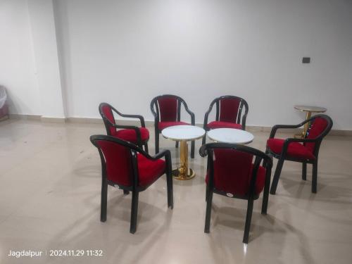 a group of chairs and a table with red chairs at Hotel MM Prestige in Jagdalpur