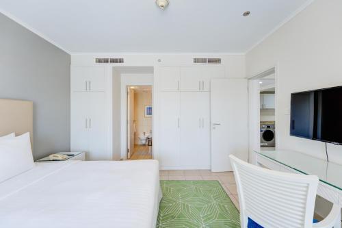 a white room with a table and two chairs at Millennium Lakeview Residences in Dubai
