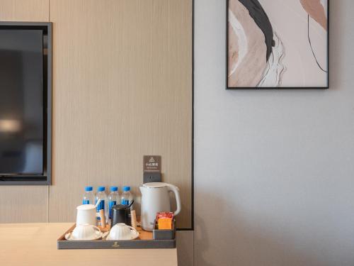 a kitchen counter with a tray with a coffee maker at Guanghan Exhibition International Hotel in Guanghan