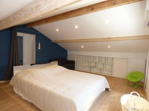 - une chambre avec un grand lit blanc et une chaise verte dans l'établissement Maison familiale les Sablettes près de la mer, à La Seyne-sur-Mer