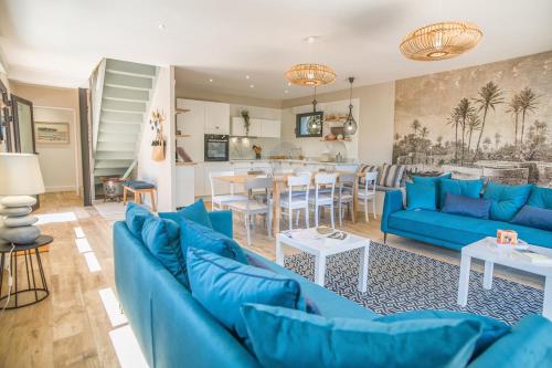 un salon avec des canapés bleus et une salle à manger dans l'établissement Belle villa moderne sous les pins au Moulleau, à La Teste-de-Buch