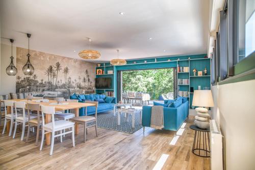 un salon avec une table et un canapé bleu dans l'établissement Belle villa moderne sous les pins au Moulleau, à La Teste-de-Buch