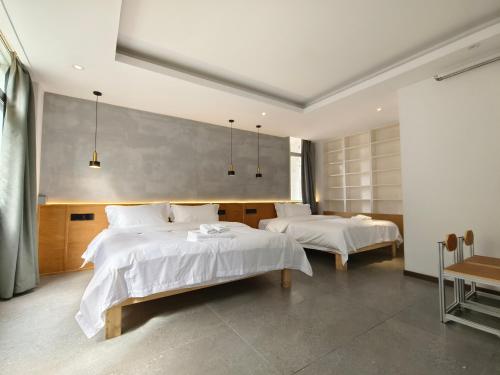 a bedroom with two beds with white sheets at West Street Hills Travel B&B in Quanzhou