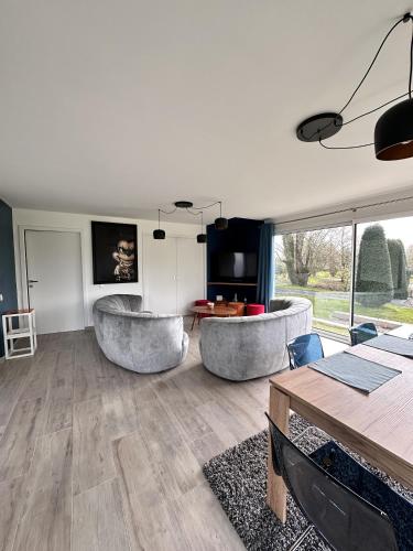 un salon avec deux chaises et une table dans l'établissement L'Opale - Plain Pied - Acces PMR, à Les Attaques