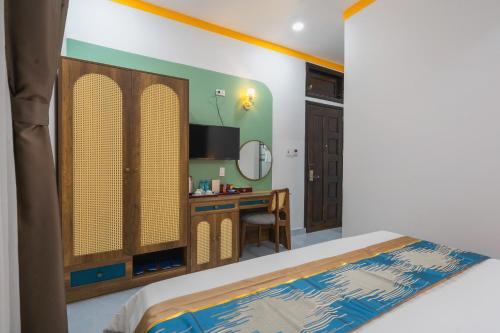 a bedroom with a bed and a desk with a mirror at ORCHID Hotel in Da Lat