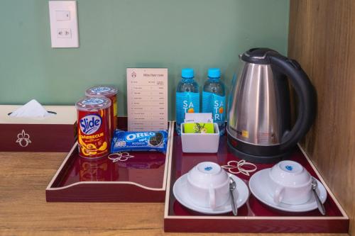 a tray with a tea kettle and cups on a table at ORCHID Hotel in Da Lat