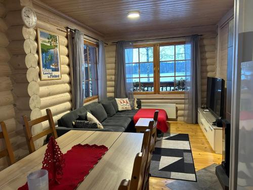 una sala de estar con un sofá y una mesa en Villa Saimaa, en Vuoriniemi