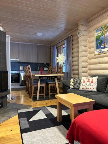 salon i kuchnia z kanapą i stołem w obiekcie Villa Saimaa w mieście Vuoriniemi