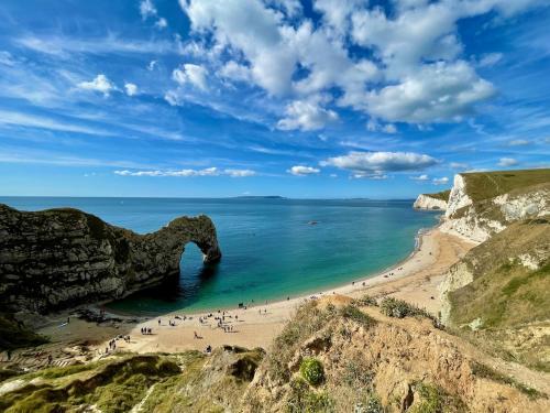 a group of people on a beach near the ocean at Durdle Door family Holiday Home in West Lulworth