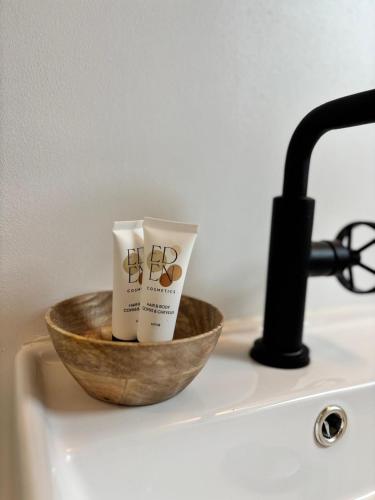 - un bol en bois avec deux tasses sur un évier dans l'établissement Au bord de Mers, à Mers-les-Bains