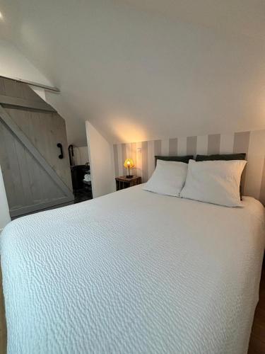 une chambre avec un grand lit avec des draps blancs dans l'établissement Au bord de Mers, à Mers-les-Bains