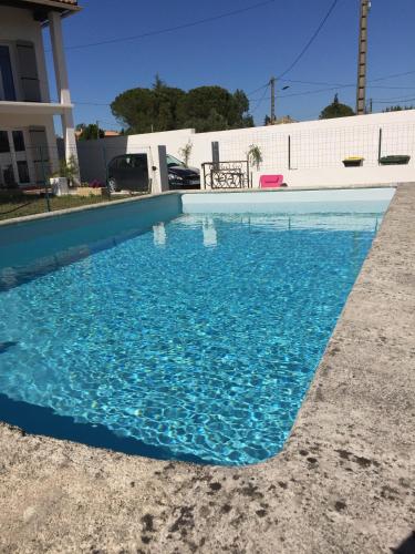 une piscine avec de l'eau bleue devant une maison dans l'établissement Courthézon Entre vignes et Village, T2 indépendant, à Courthézon