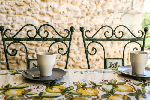 two cups and saucers sitting on a table at Le mas du Four a Chaux in Gordes