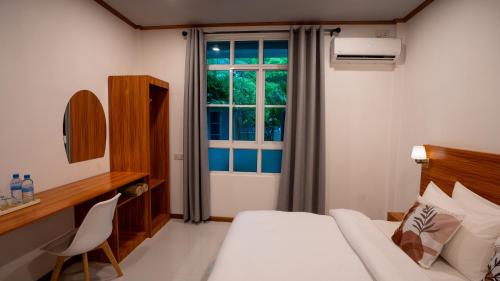 GaafaruにあるSunrise Lagoonのベッドと窓のあるホテルの部屋