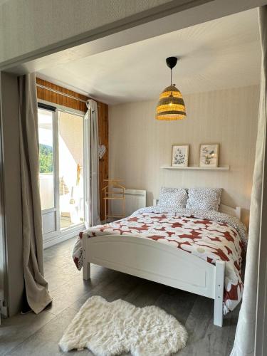 une chambre avec un lit blanc et une fenêtre dans l'établissement Le Refuge, à La Bresse