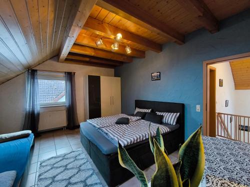 a bedroom with a bed and a couch in a room at Ferienhaus Goldgrube - 5 Zimmer - 140qm am Fluss in Katzweiler