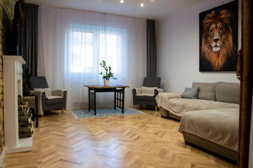 a living room with a lion painting on the wall at Season One Apartman in Szeged
