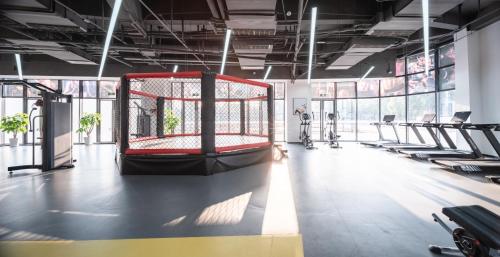 a gym with a red cage in the middle of a room at Guanghan Exhibition International Hotel in Guanghan