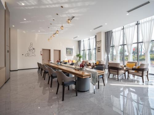 a dining room with a long table and chairs at Guanghan Exhibition International Hotel in Guanghan