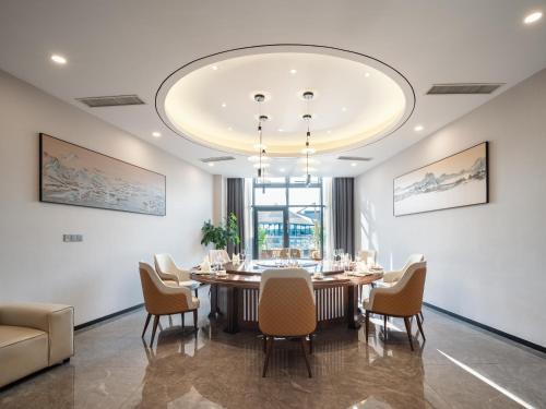a dining room with a large table and chairs at Guanghan Exhibition International Hotel in Guanghan