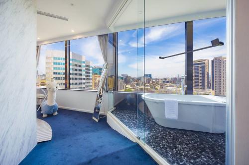 a bathroom with a tub with a view of a city at 苓旅松山館 Lininn Tapei Arena in Taipei