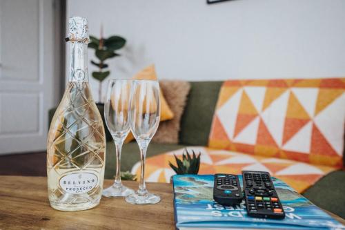 a bottle of wine and two glasses on a table at Cozy Waterfront Apartment - Free Parking & Wi-Fi in Preston
