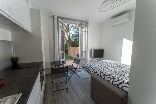 ein Schlafzimmer mit Bett und eine Küche mit Spüle in der Unterkunft Studio cosy avec jardin privatif proche transport in Vénissieux