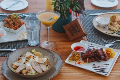 a table with plates of food and a glass of wine at Oasis Blu Beach Resort-Adults Only in Nungwi