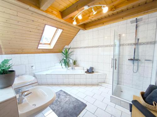 a bathroom with a tub and a shower and a sink at Ferienhaus Goldgrube - 5 Zimmer - 140qm am Fluss in Katzweiler