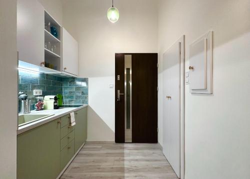 a kitchen with a hallway with a door and a sink at Colorful Condo by the Danube ---FREE PARKING--- in Budapest