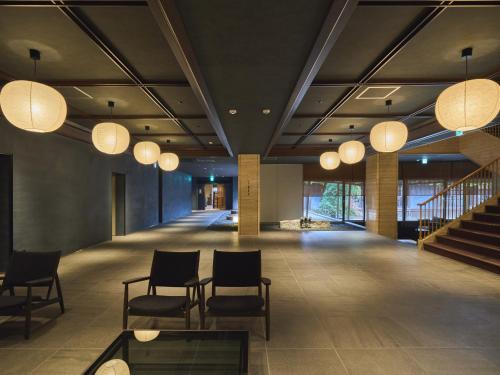 a lobby with chairs and lights on the ceiling at Ohana in Yanagawa