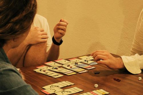 two people sitting at a table playing a board game at The Hostel in Mirissa