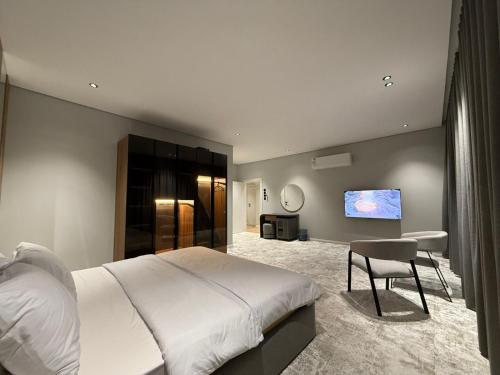 a bedroom with a large bed and a tv at فيلا روبي in Buraydah