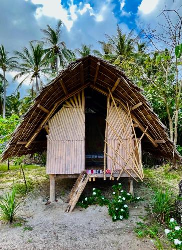 a thatched hut with palm trees in the background at Ermon Sea Side View in El Nido