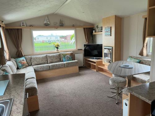 a living room with a couch and a table at Chrissys Caravan in Mablethorpe
