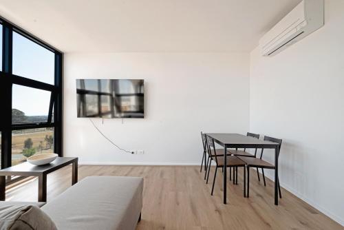 a white living room with a table and chairs at Brand New Modern 2BR Apt with Scenic Views in CBR in Harrison