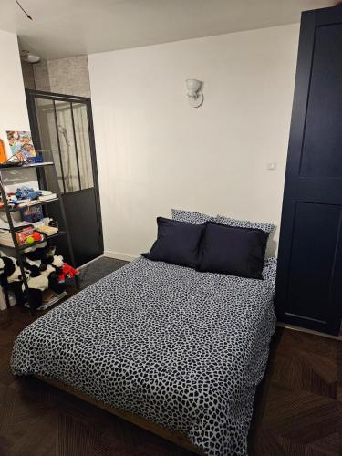 une chambre avec un lit avec une couette noire et blanche dans l'établissement Chez Isa et Geo le studio Jules, à Laguian-Mazoux